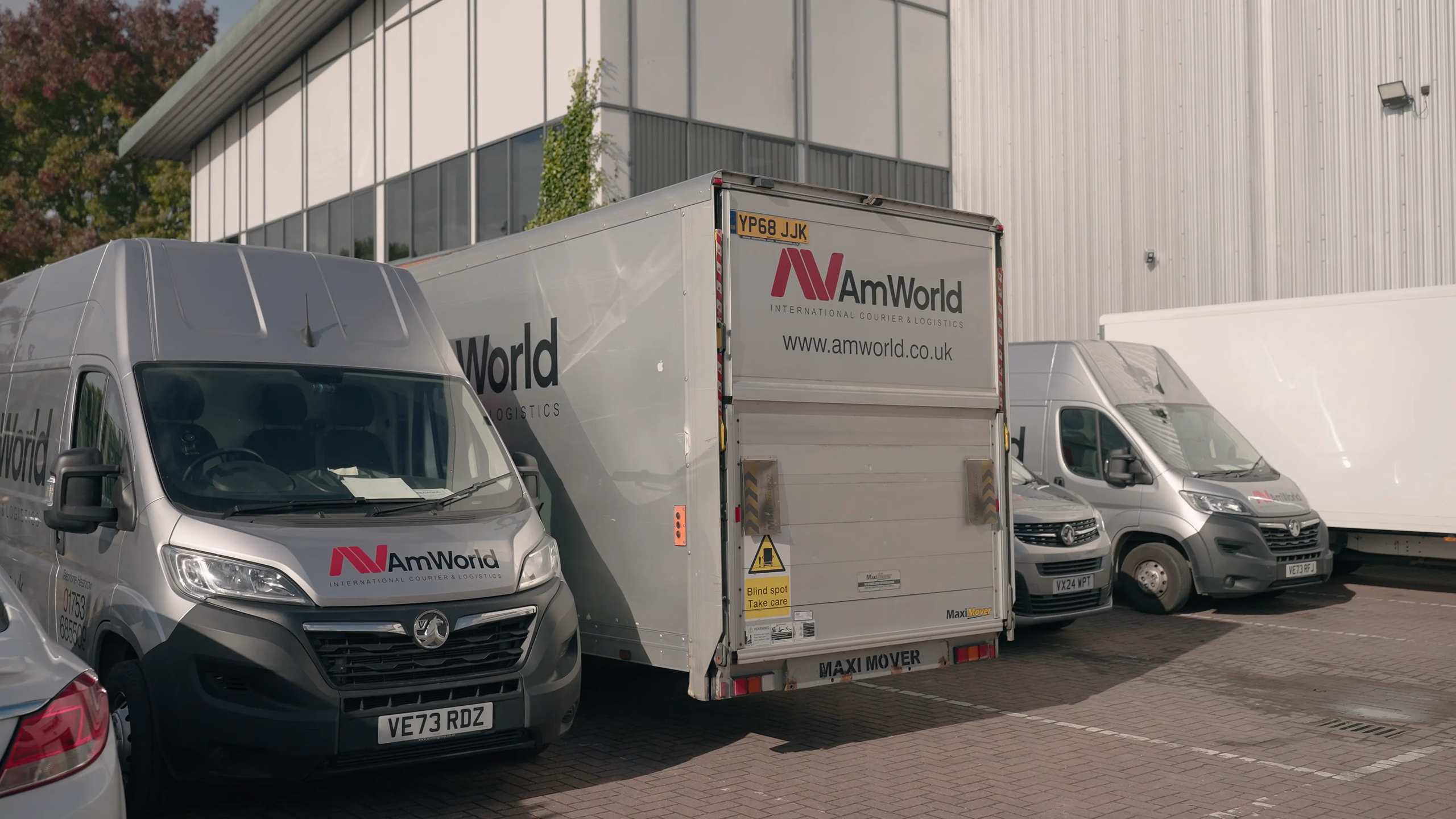 AMWORLD delivery vehicles outside the company's premises