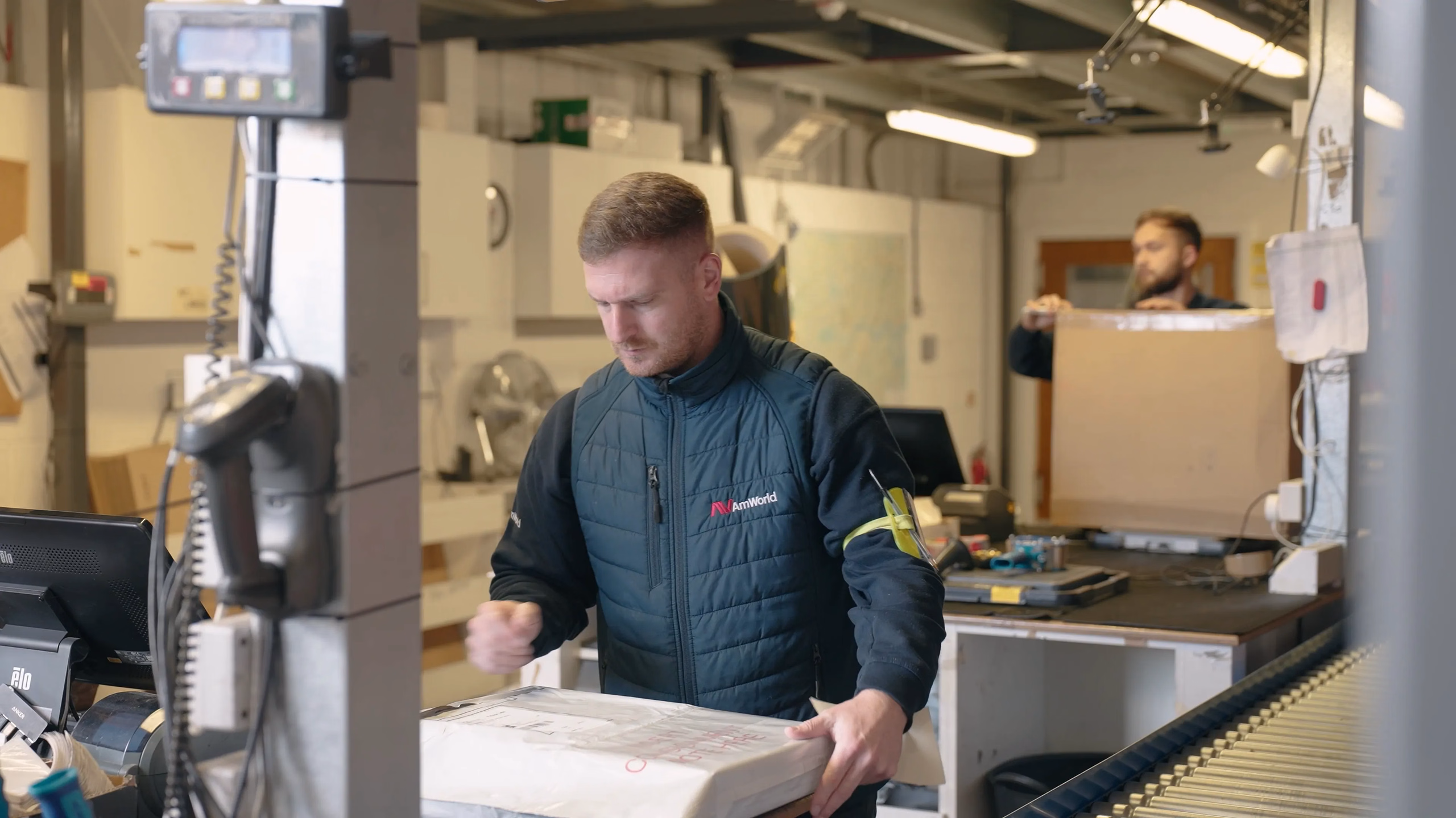 AMWORLD team member handling a parcel at a packing station