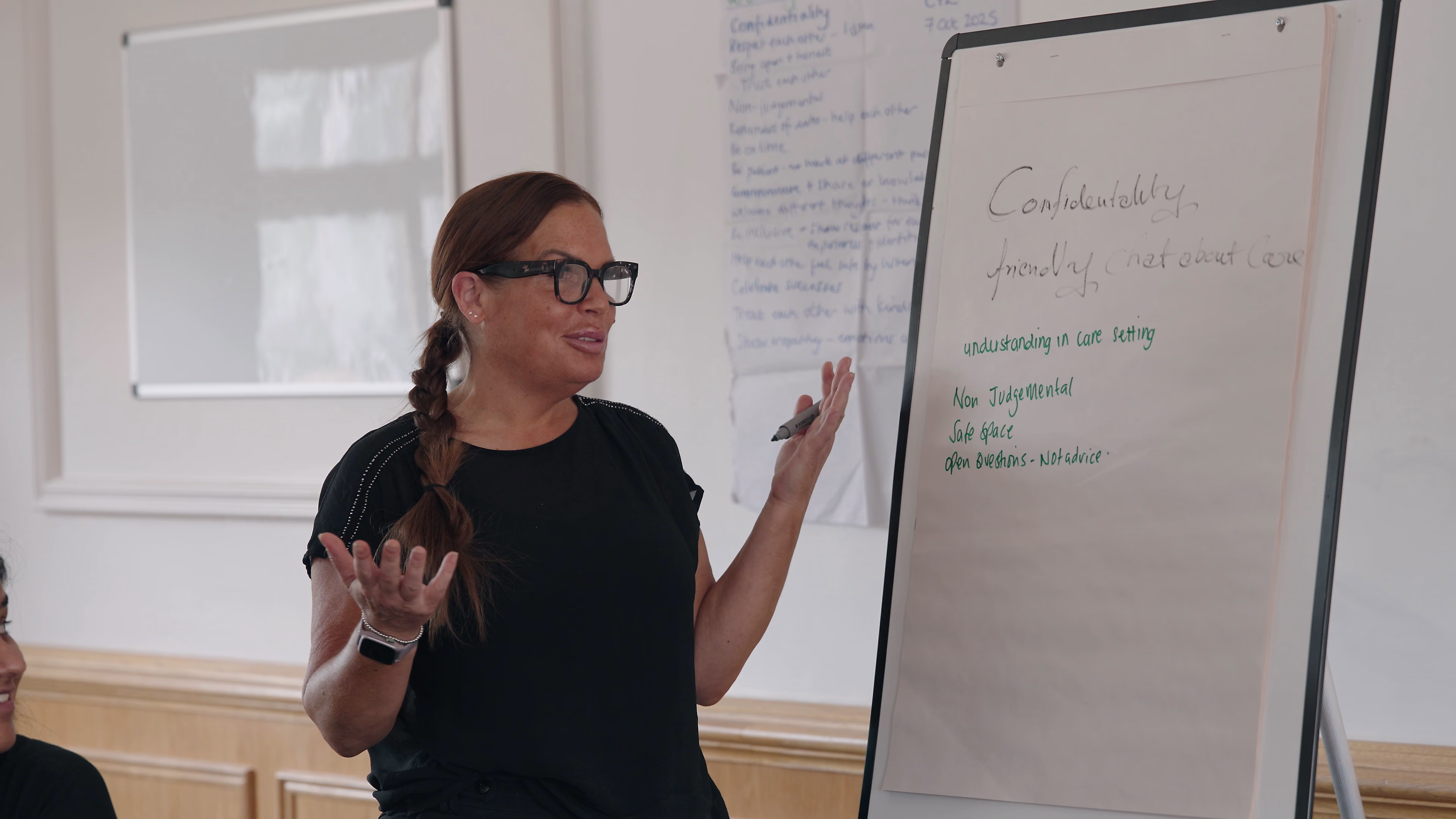 Programme facilitator leading a discussion beside written learning notes