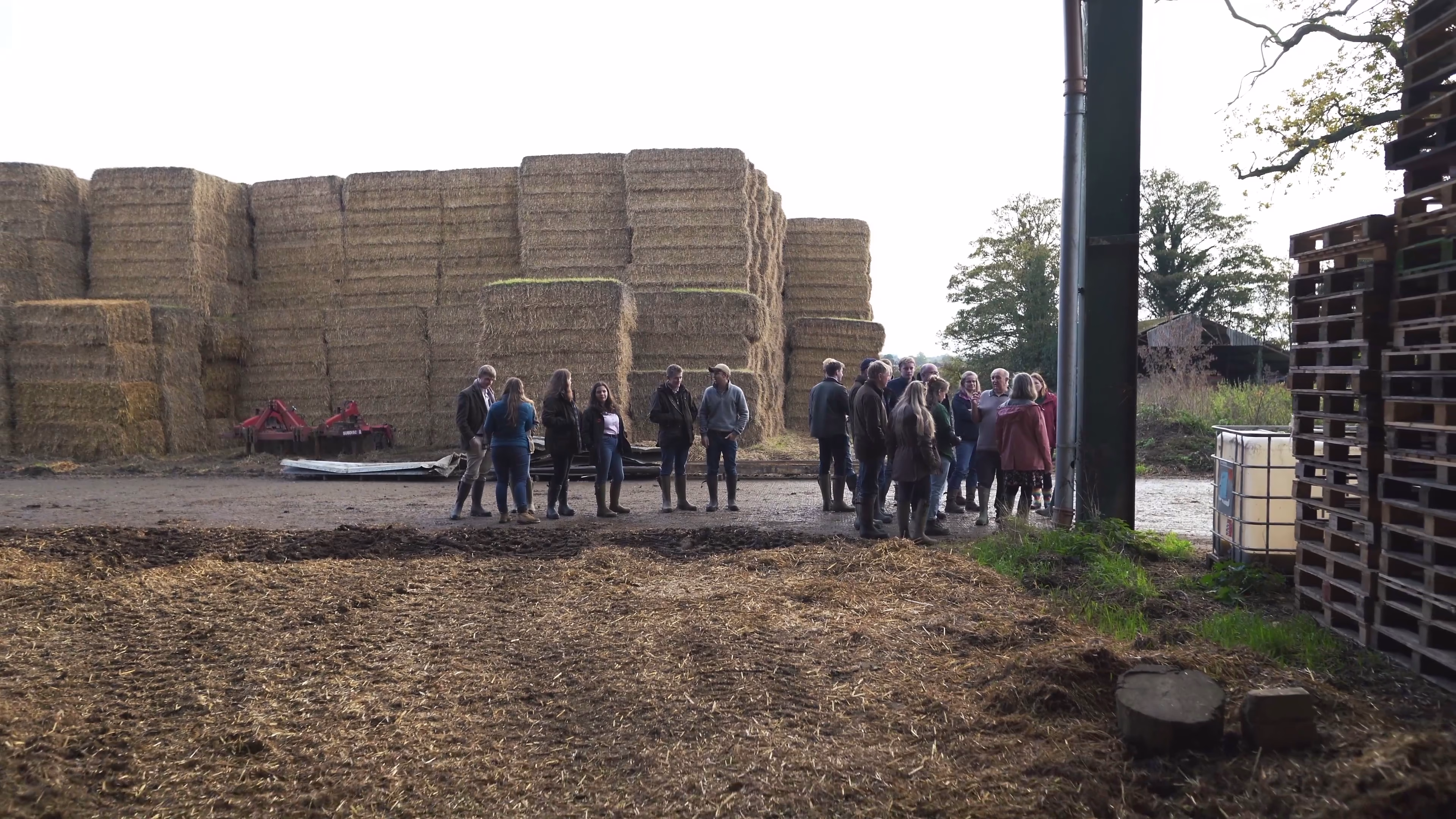 The bursary group beside stacked agricultural materials