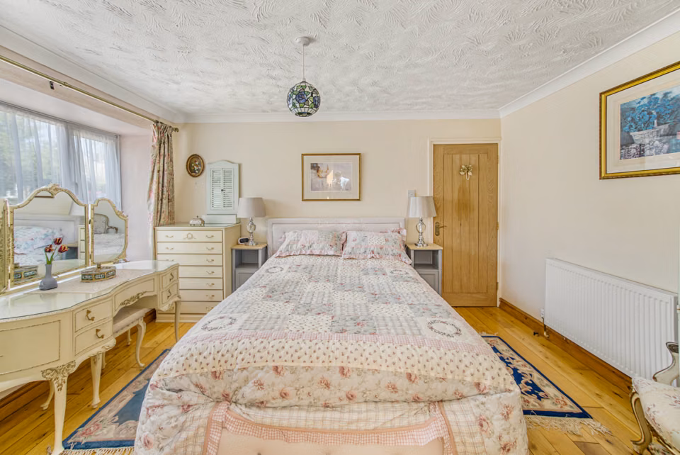Bed flanked by fitted storage and dressing furniture — Cavendish