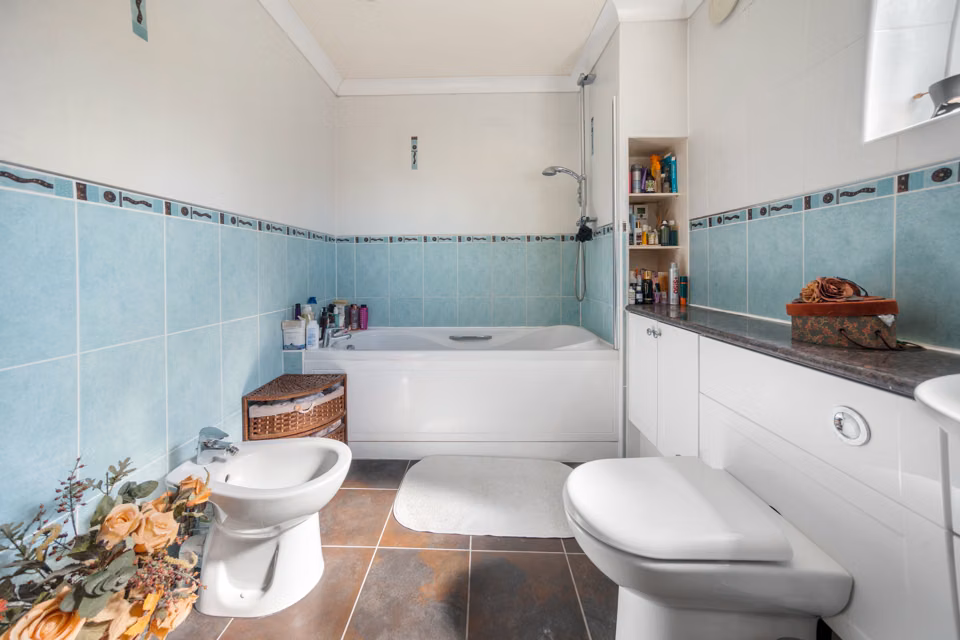 Bath and toilet beneath the bathroom window — 13 Furness Close