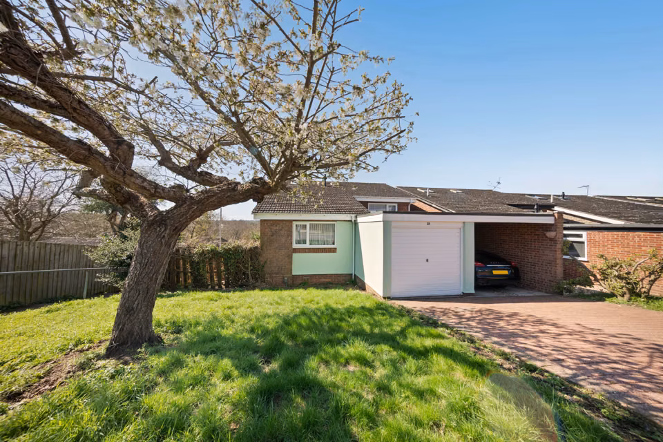 Garage and driveway framed by a mature tree — 13 Furness Close