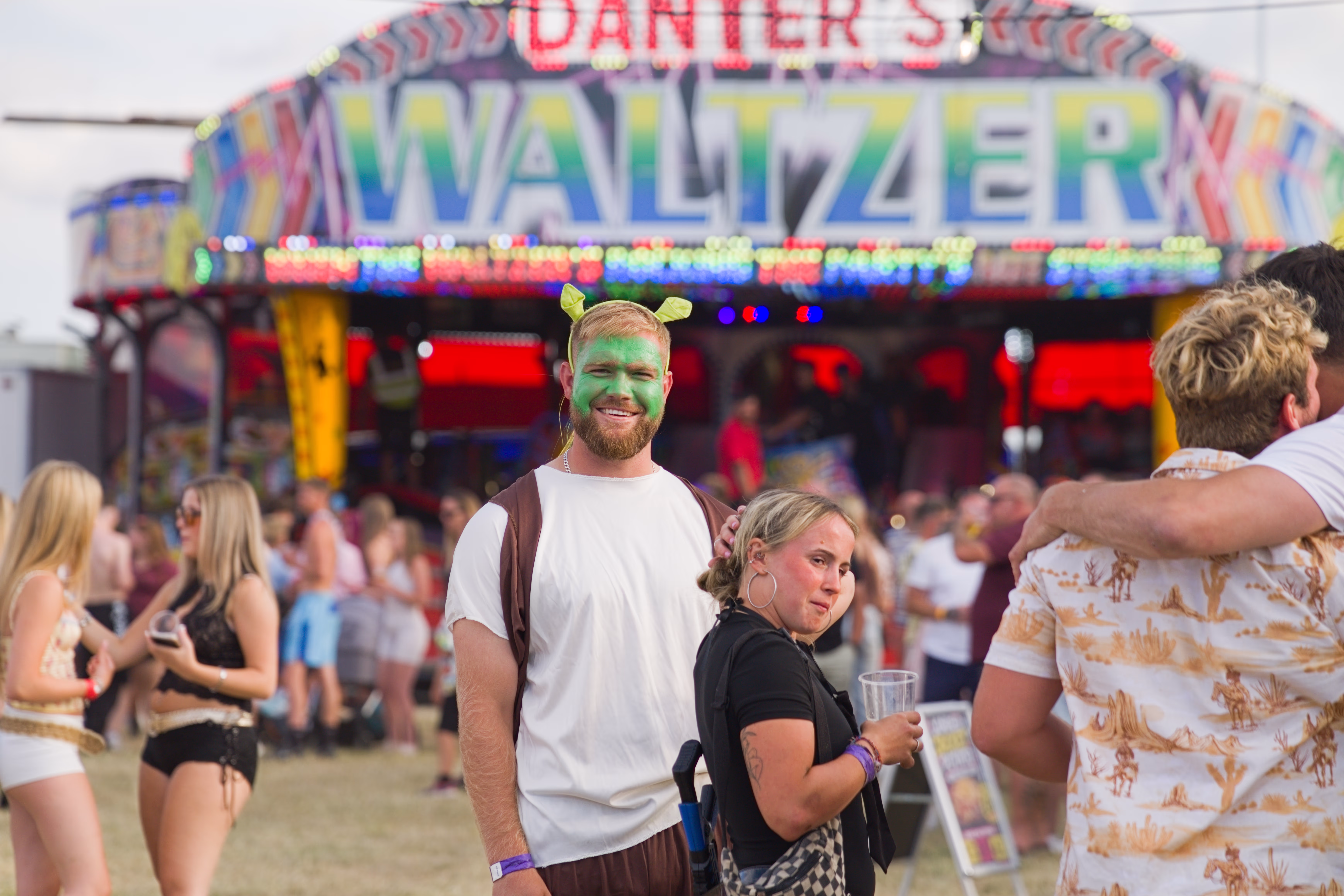 Festival crowd and fairground ride at the Cheltenham rugby event