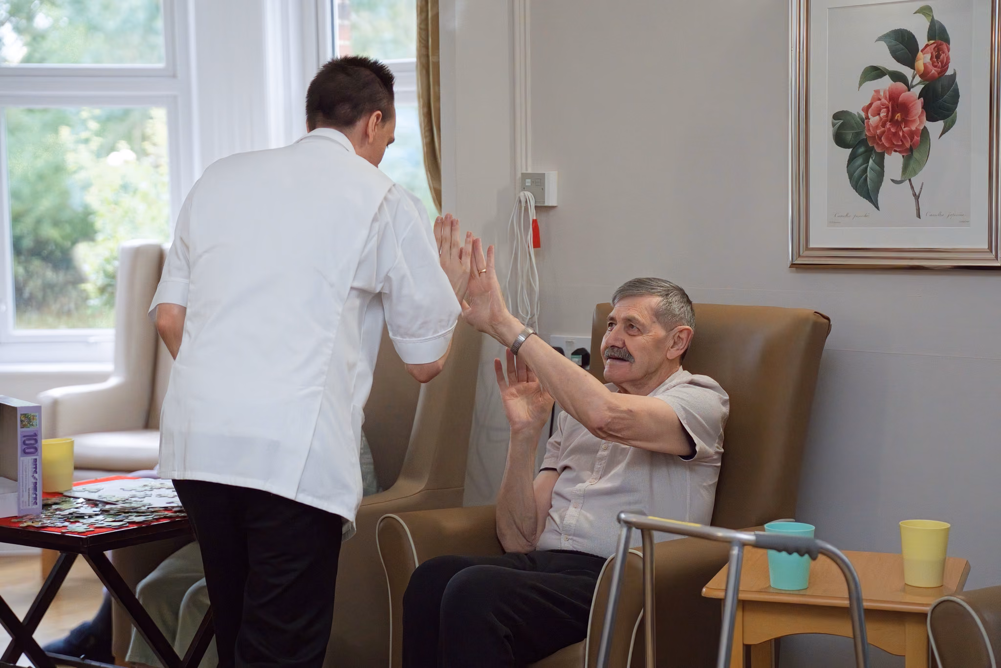 A resident and a staff member sharing a high five