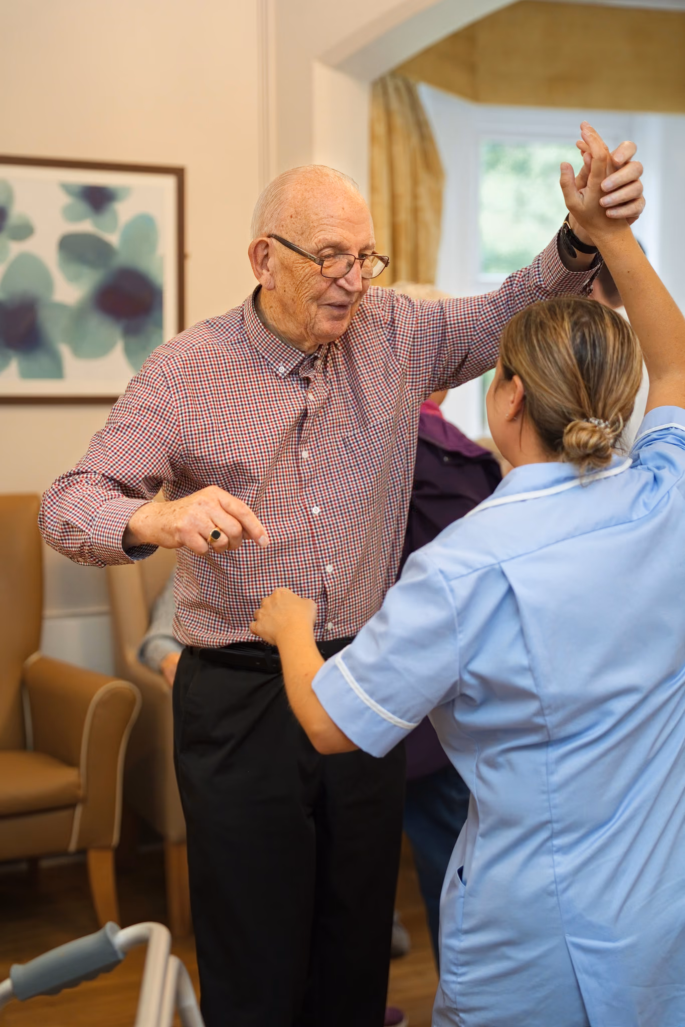 A resident dancing with a member of the care team
