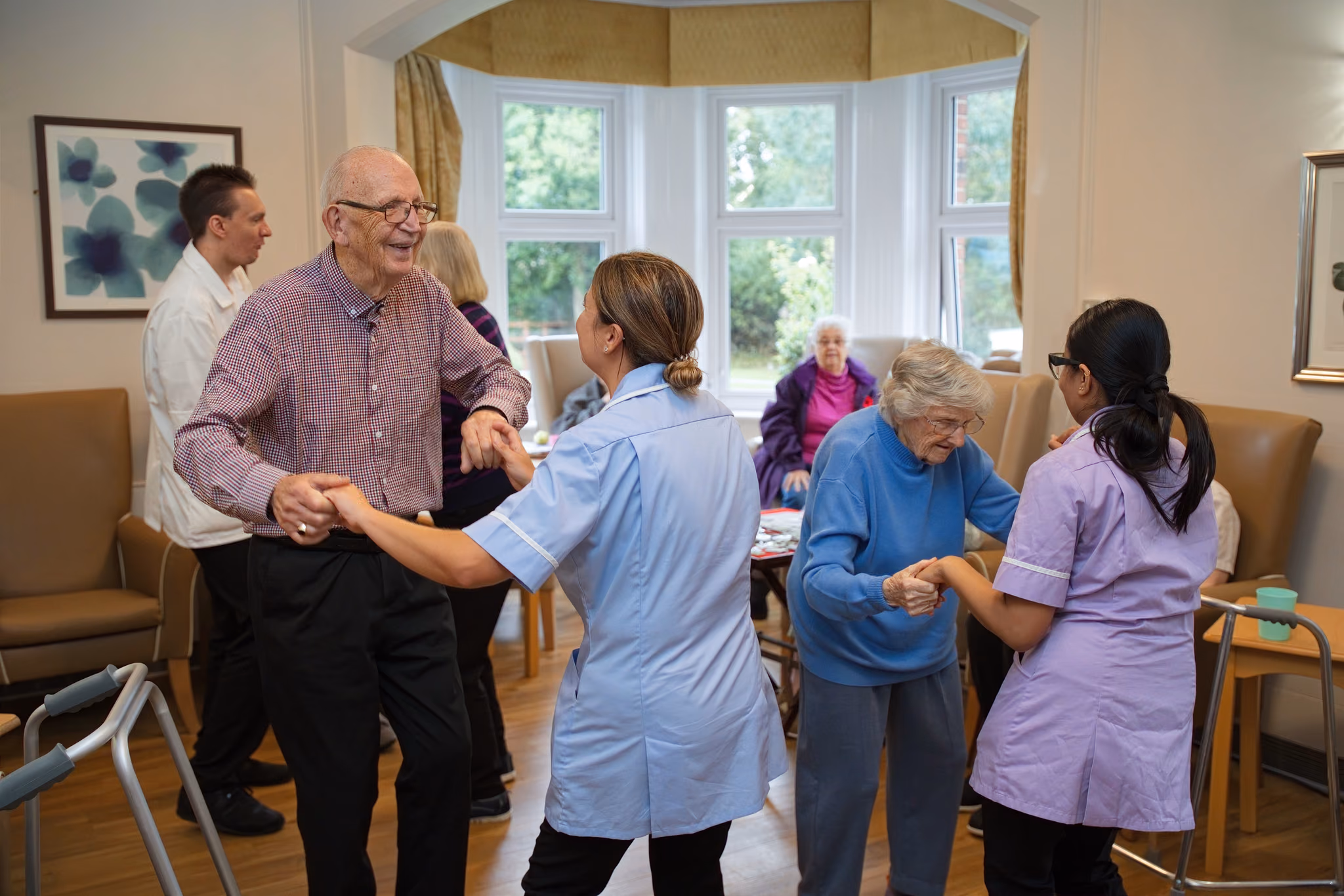 Residents dancing with members of the care team