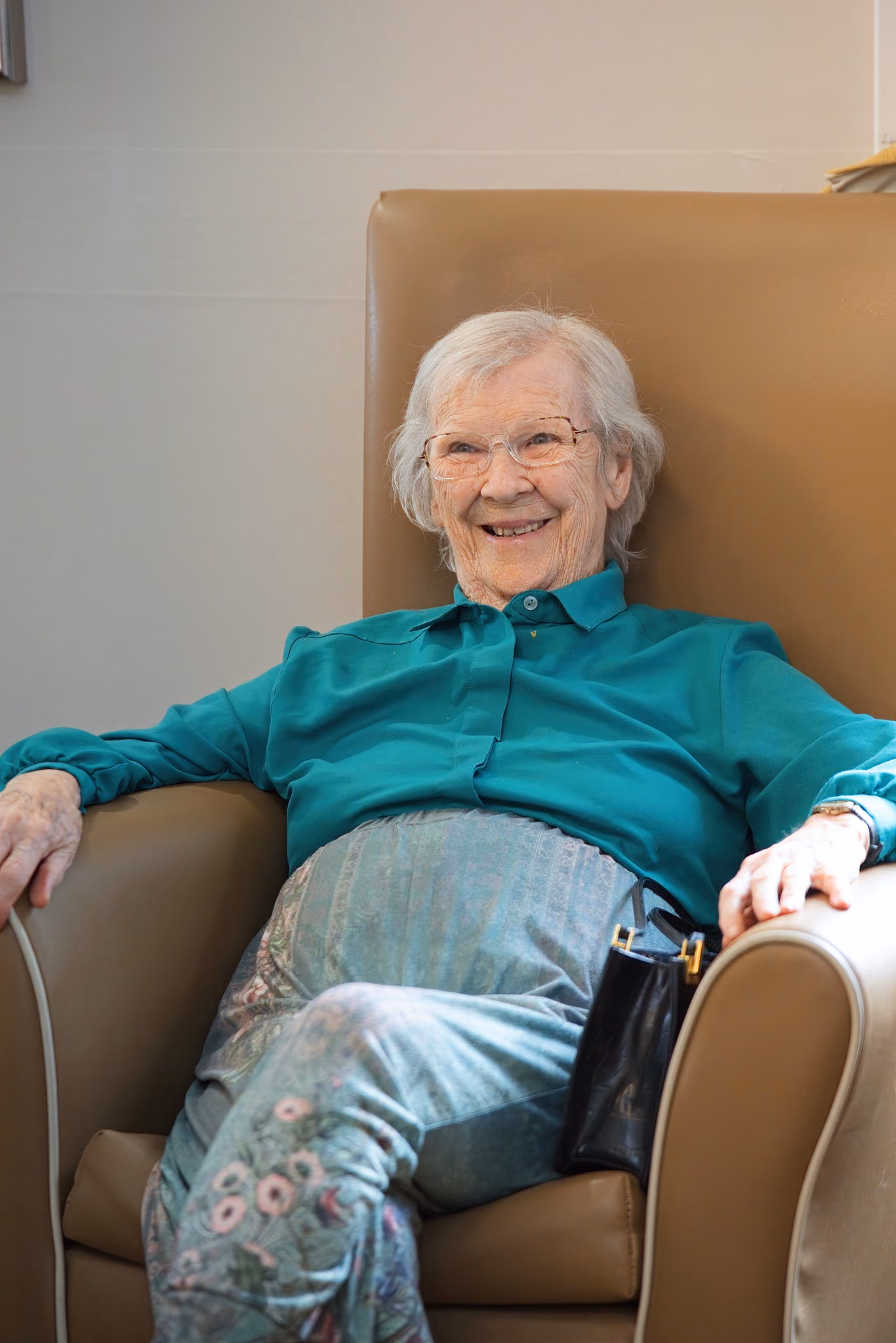 A resident laughing in her armchair