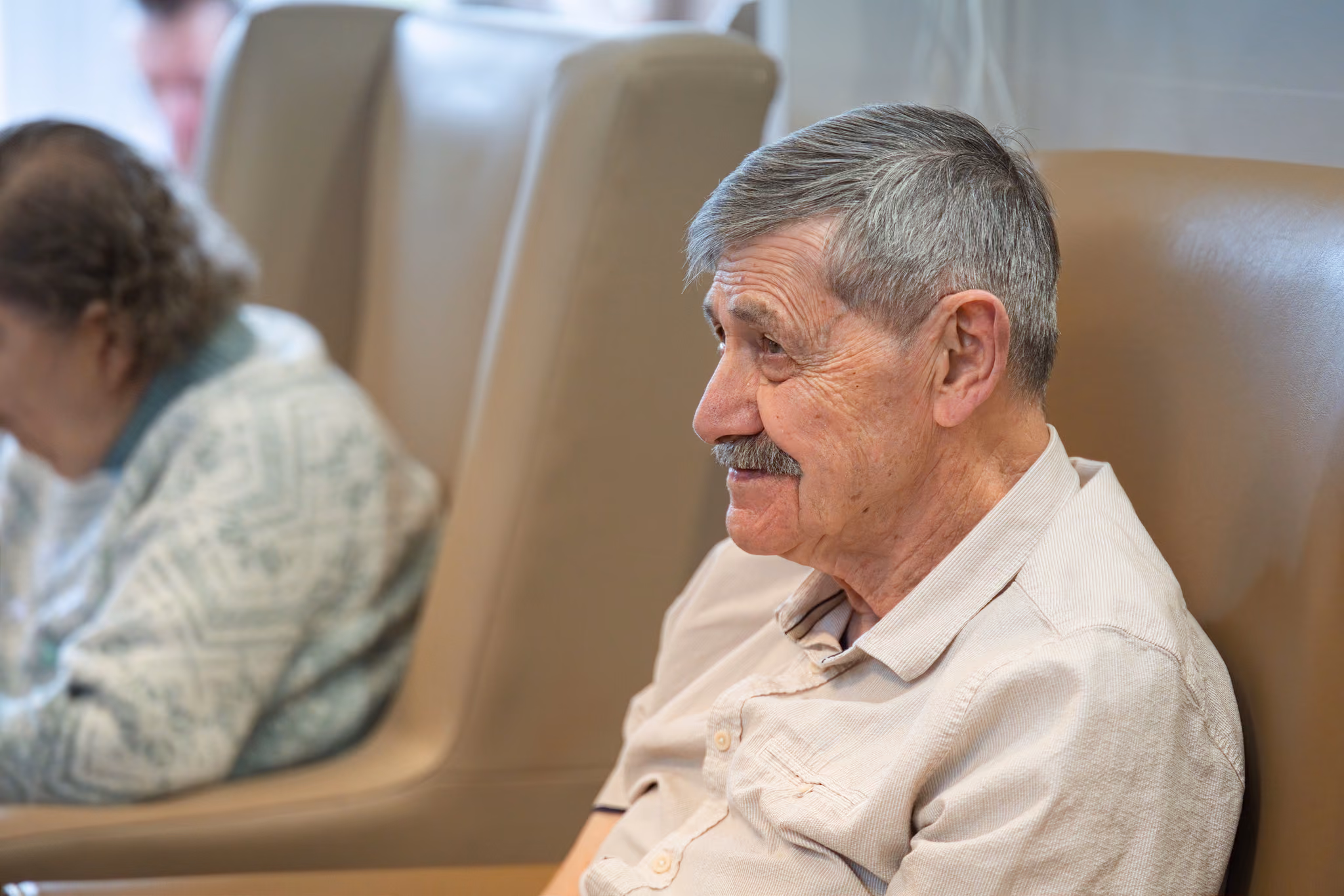 A seated resident smiling in profile