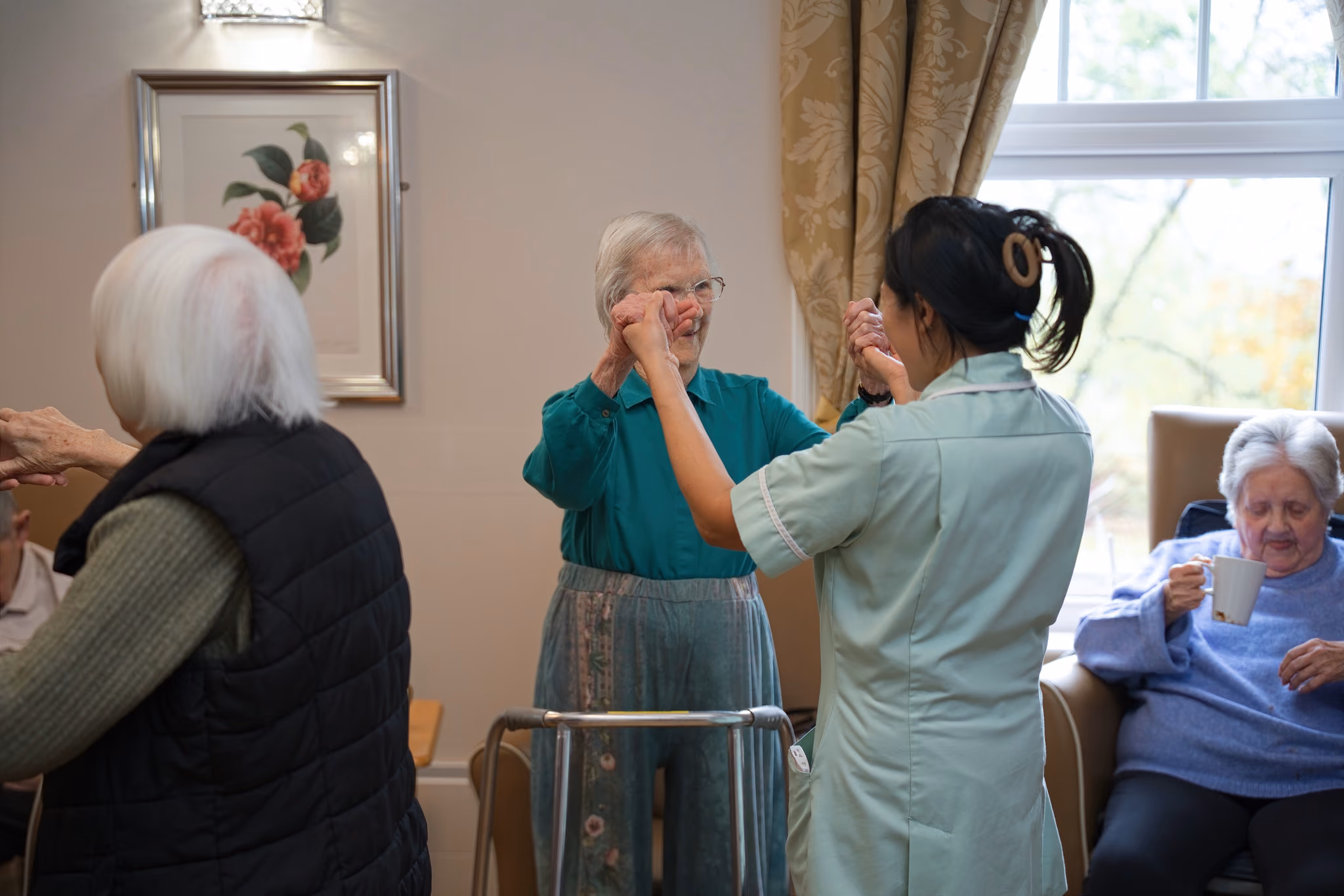 A resident and a carer raising their hands together