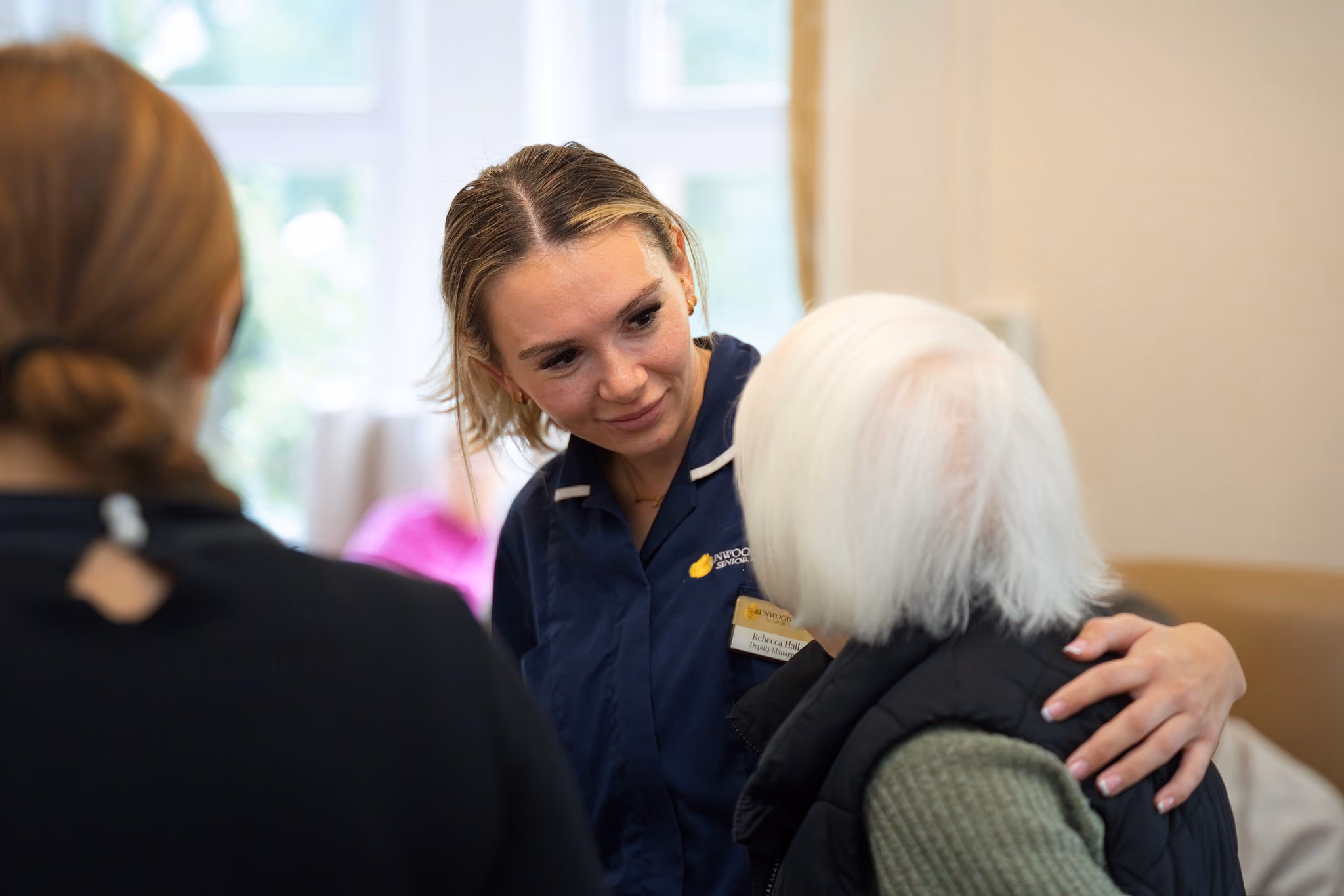 A member of the care team with her arm around a resident