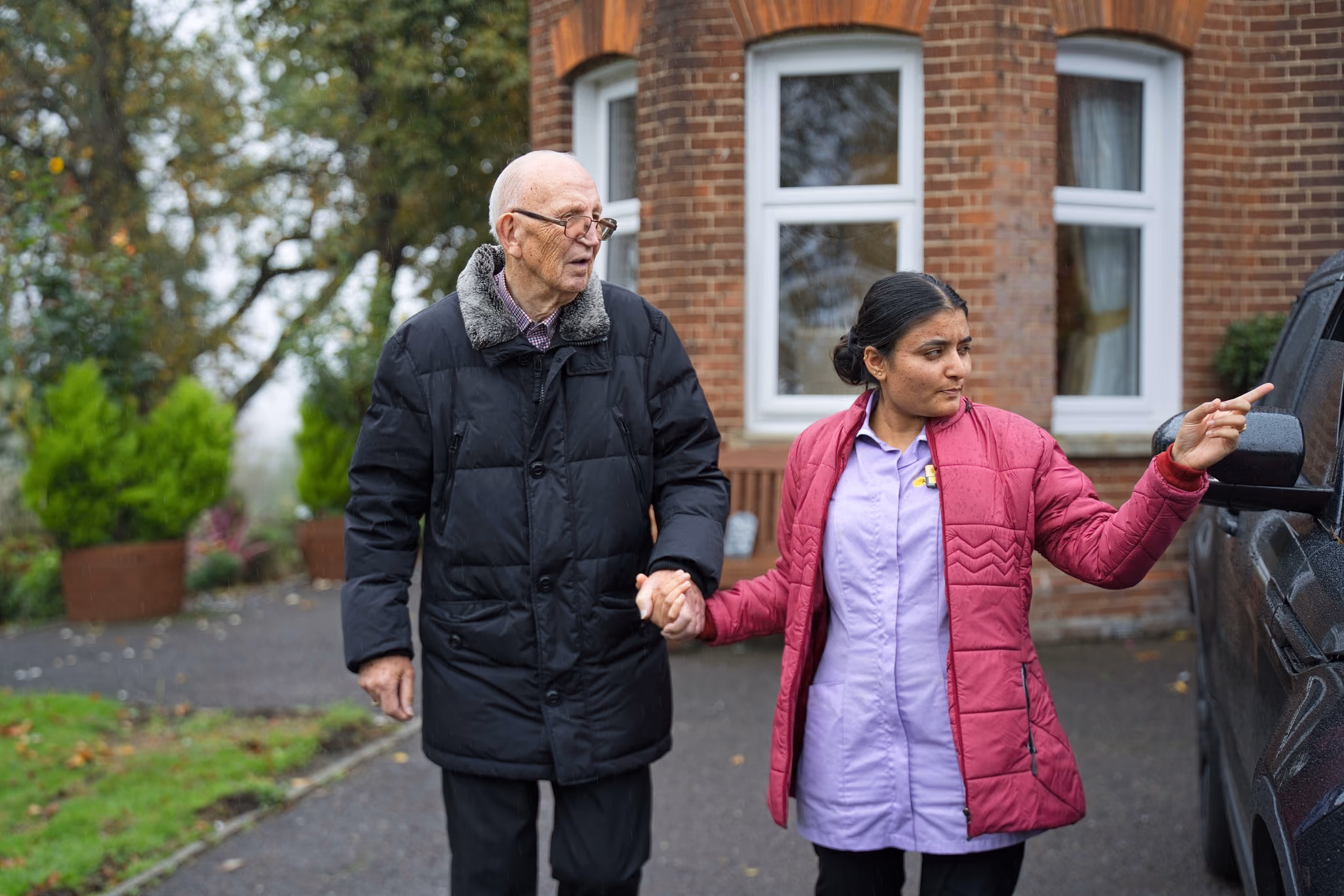 A resident and companion walking outside Eastham Care Home