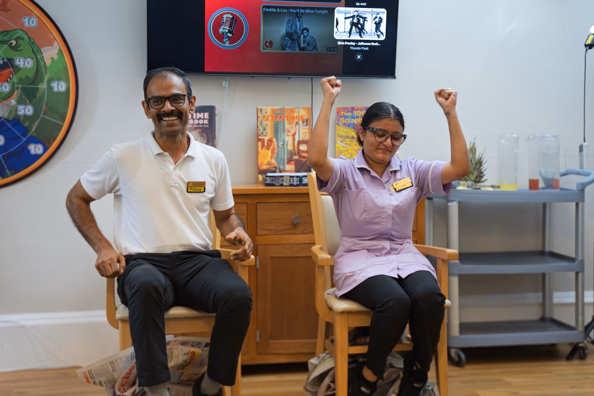 Two staff members joining a seated group game