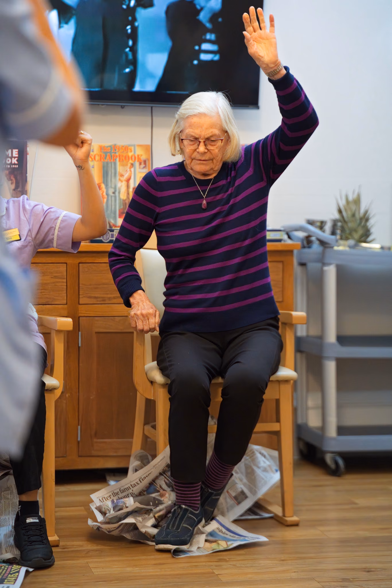 A resident raising her arm during a seated game