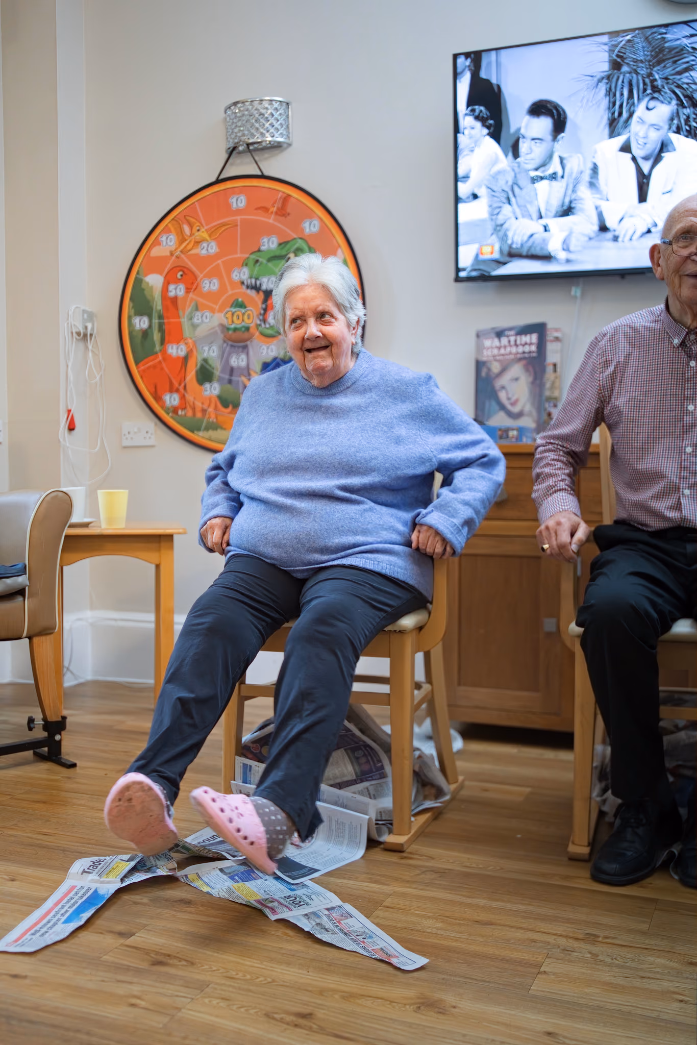 A resident laughing during a seated activity