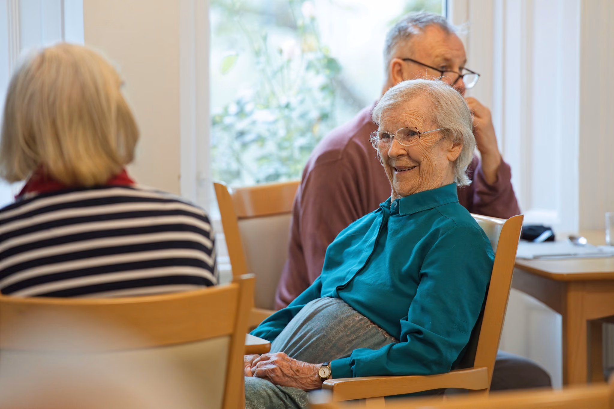 A resident sharing a conversation in the dining room