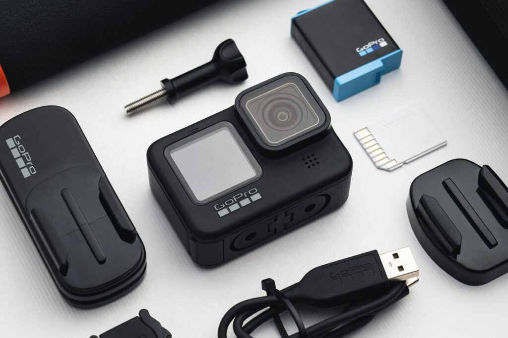 An action camera laid out with its mounts, battery and accessories
