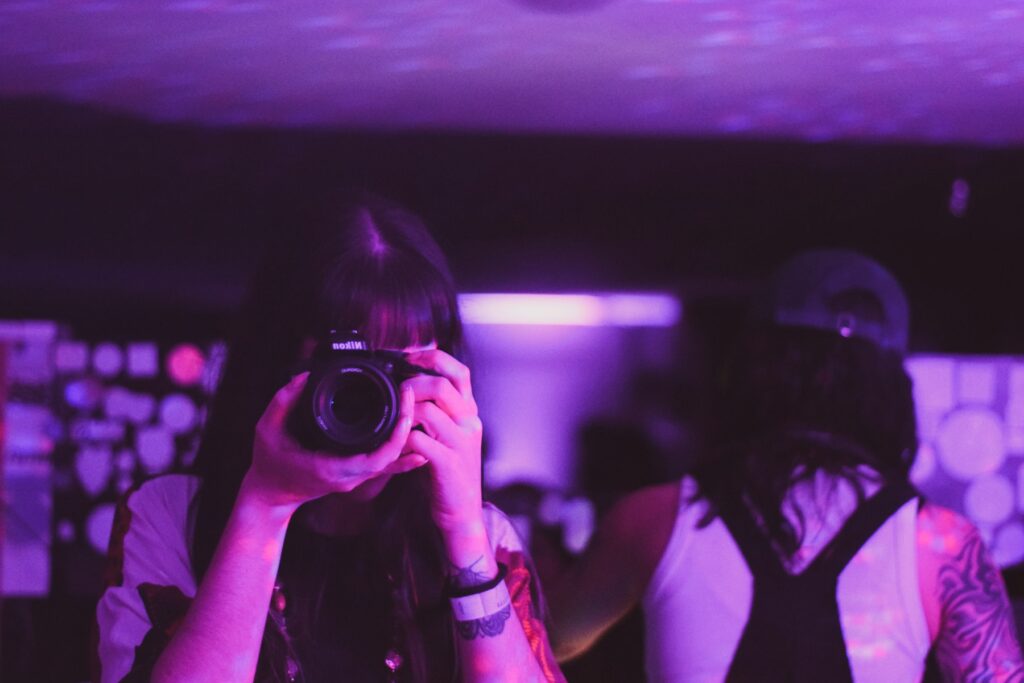 A photographer shooting under purple party lighting