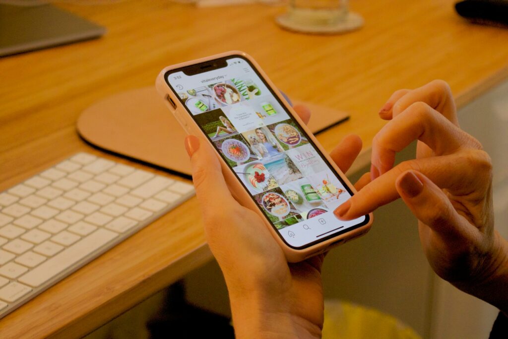 A person tapping through Instagram on a phone at a desk