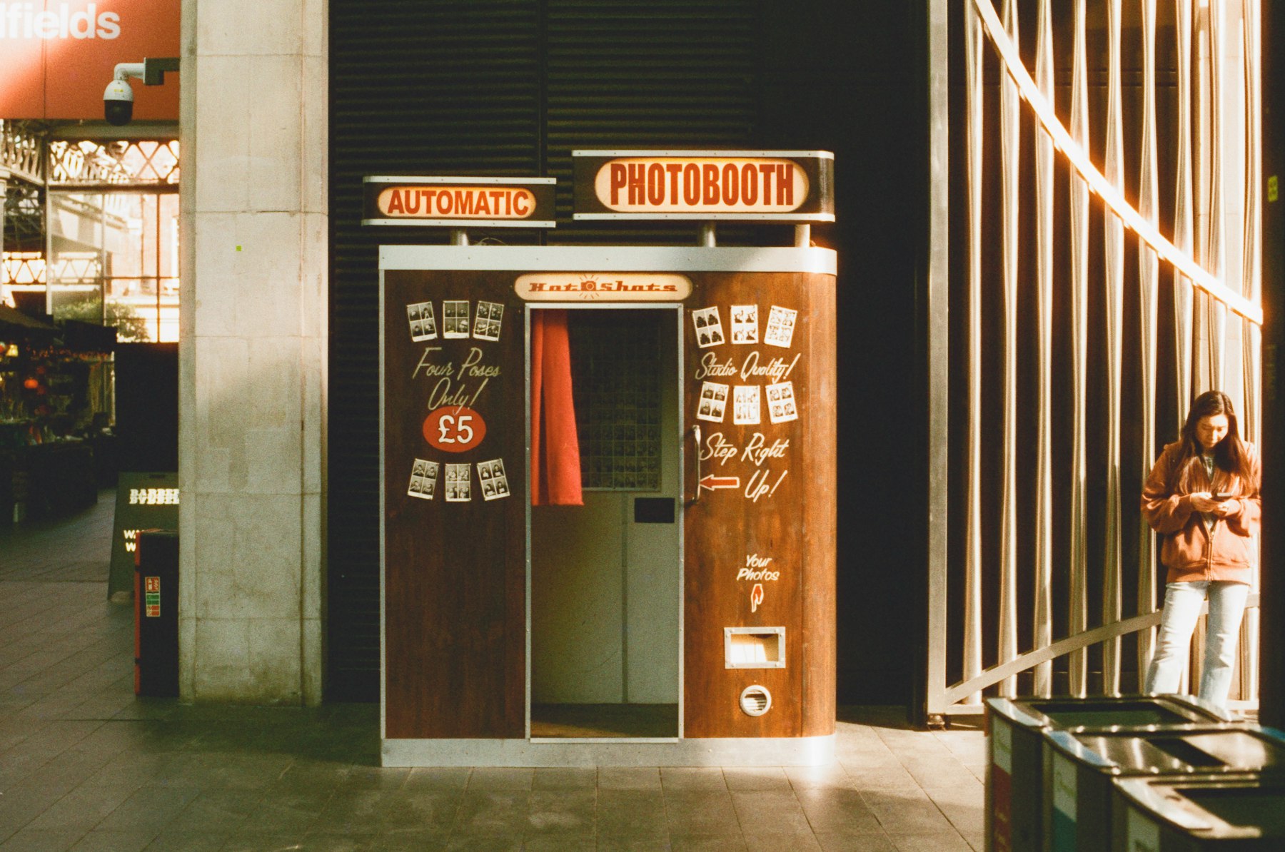 A vintage-style automatic photo booth in a city arcade