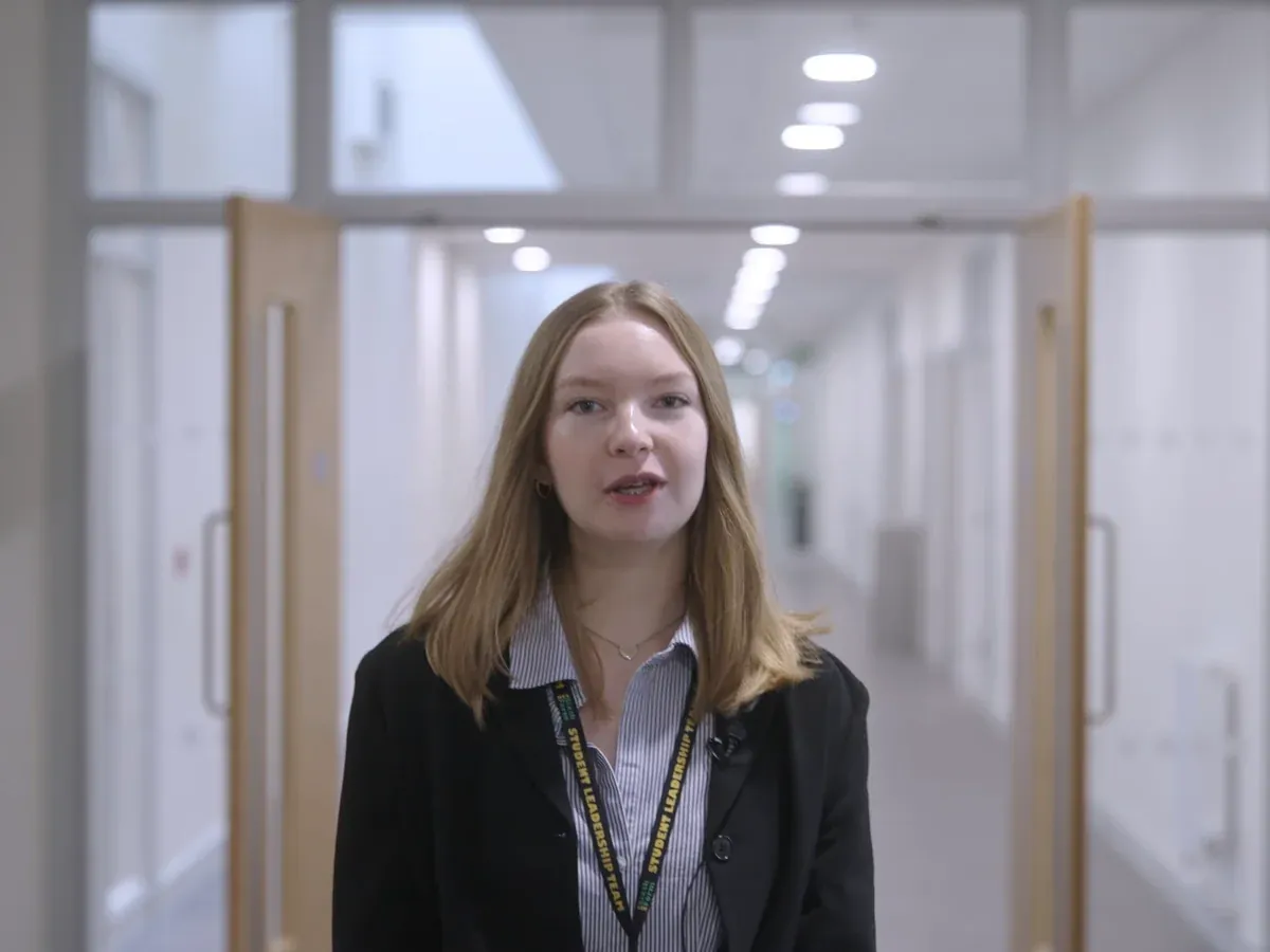 Student speaking to camera in a corridor