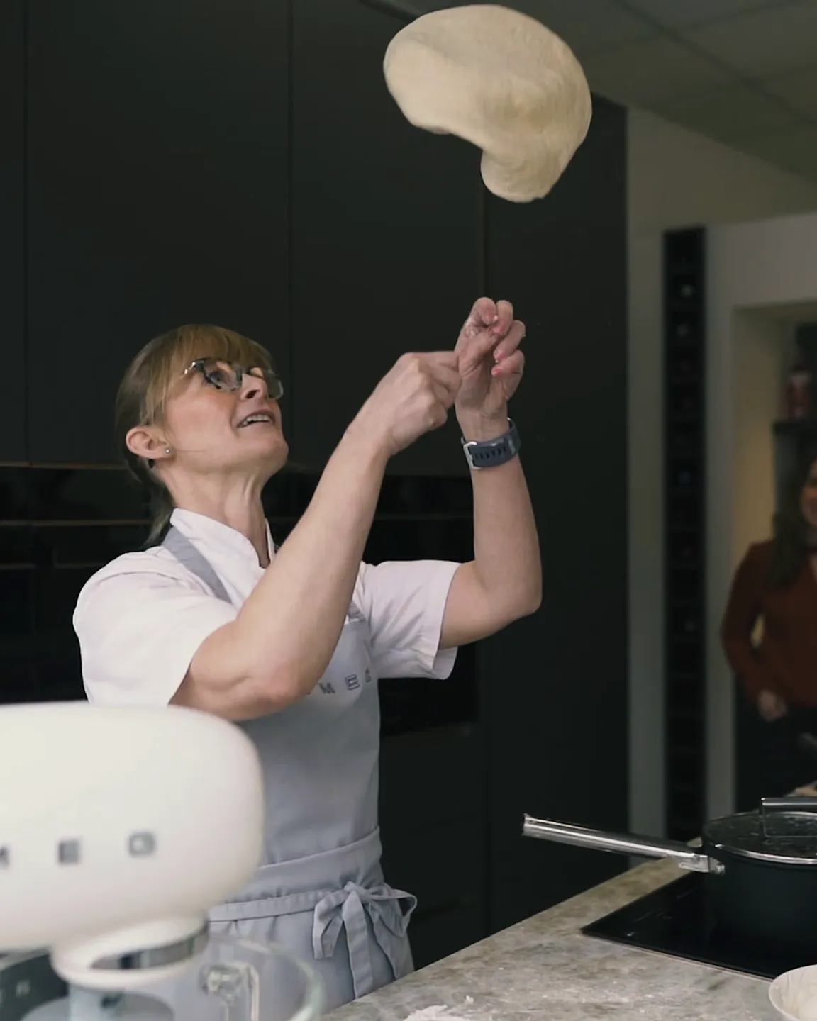 Chef tossing pizza dough in the showroom