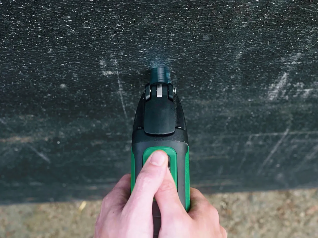 Multi-tool cutting through a dark board