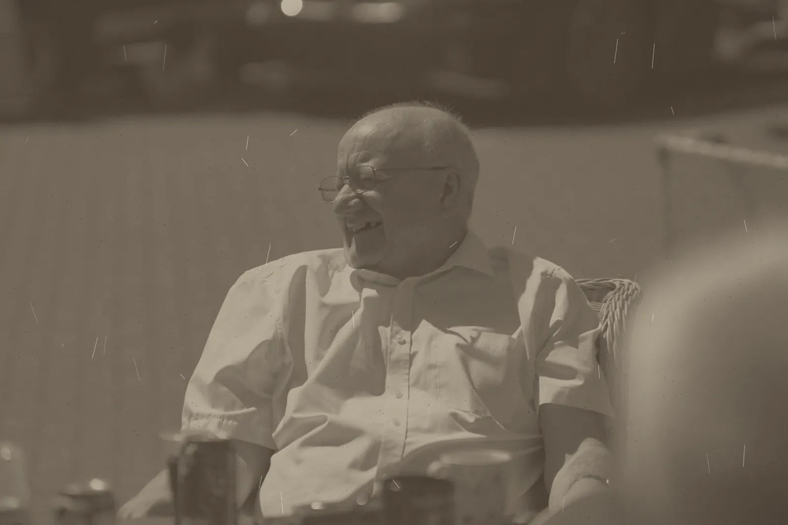 Faded, scratched photograph of a man laughing