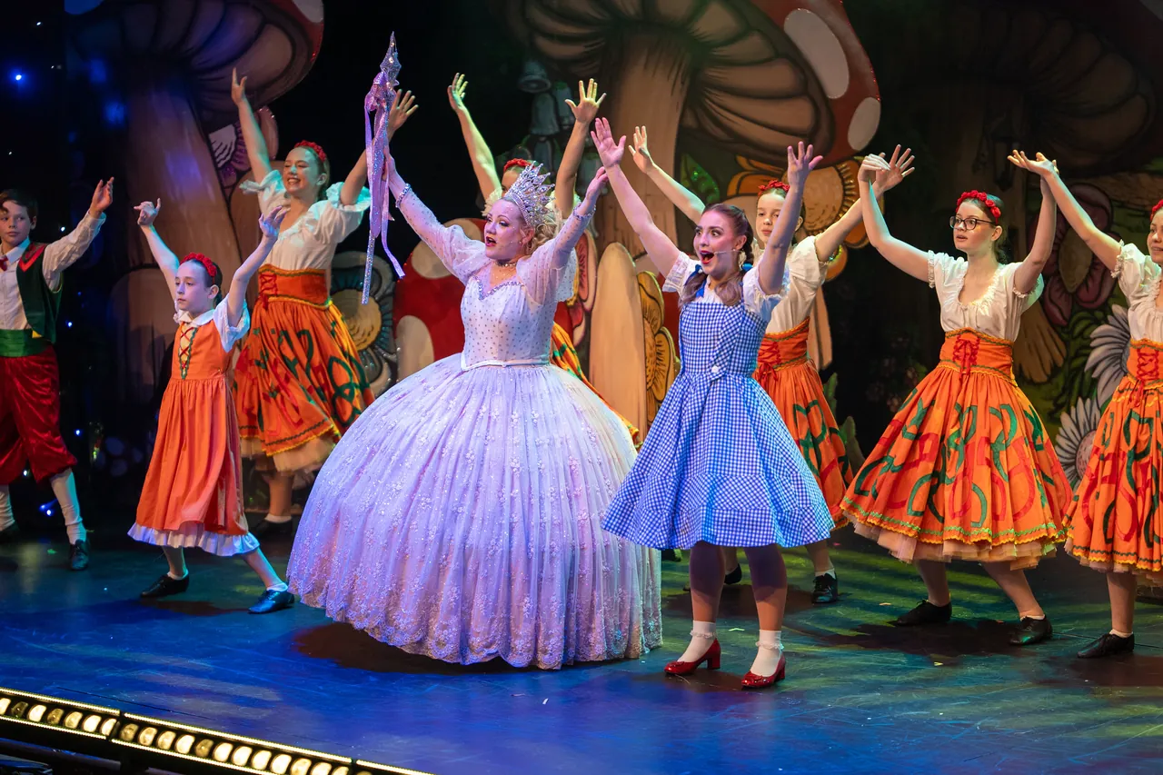 Full cast and dancers in a colourful ensemble number on stage