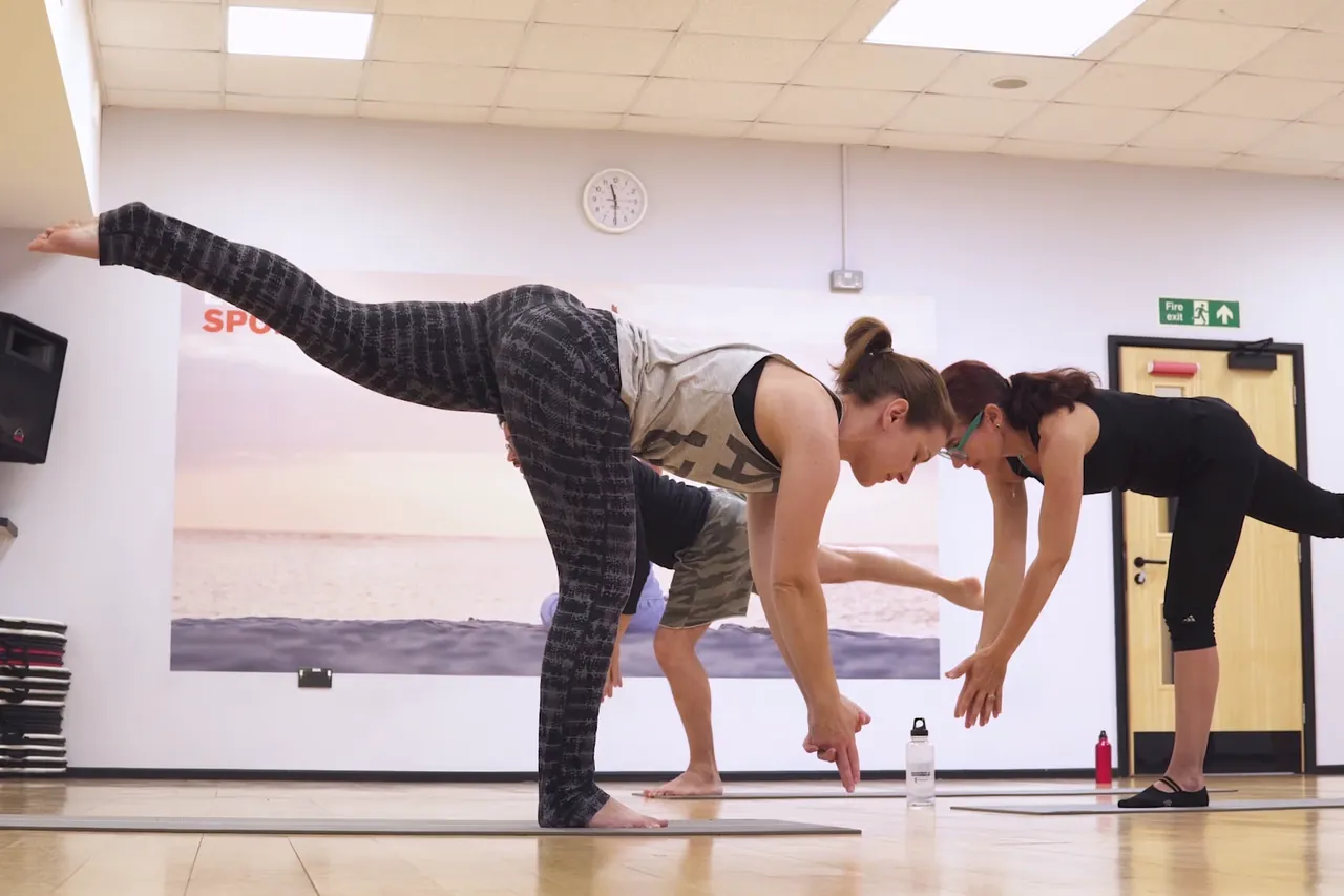 Yoga participants holding a balance pose