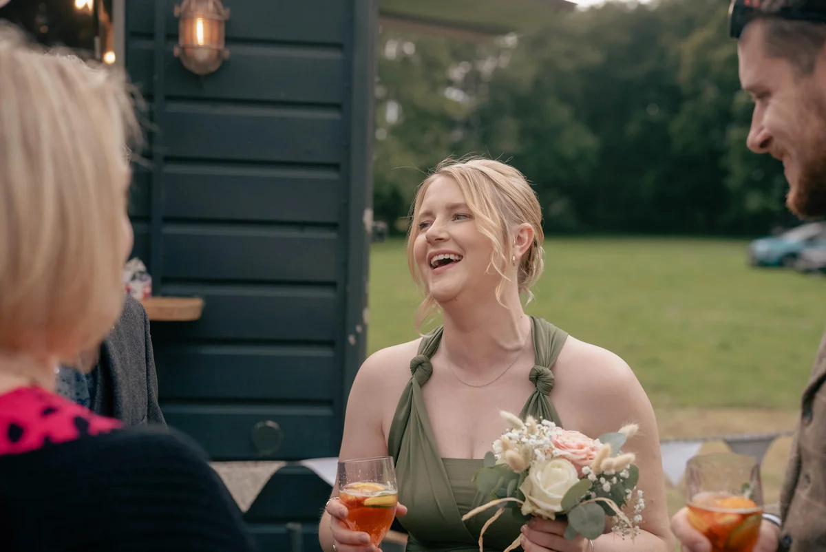 A bridesmaid laughing at Alice and Alex’s wedding