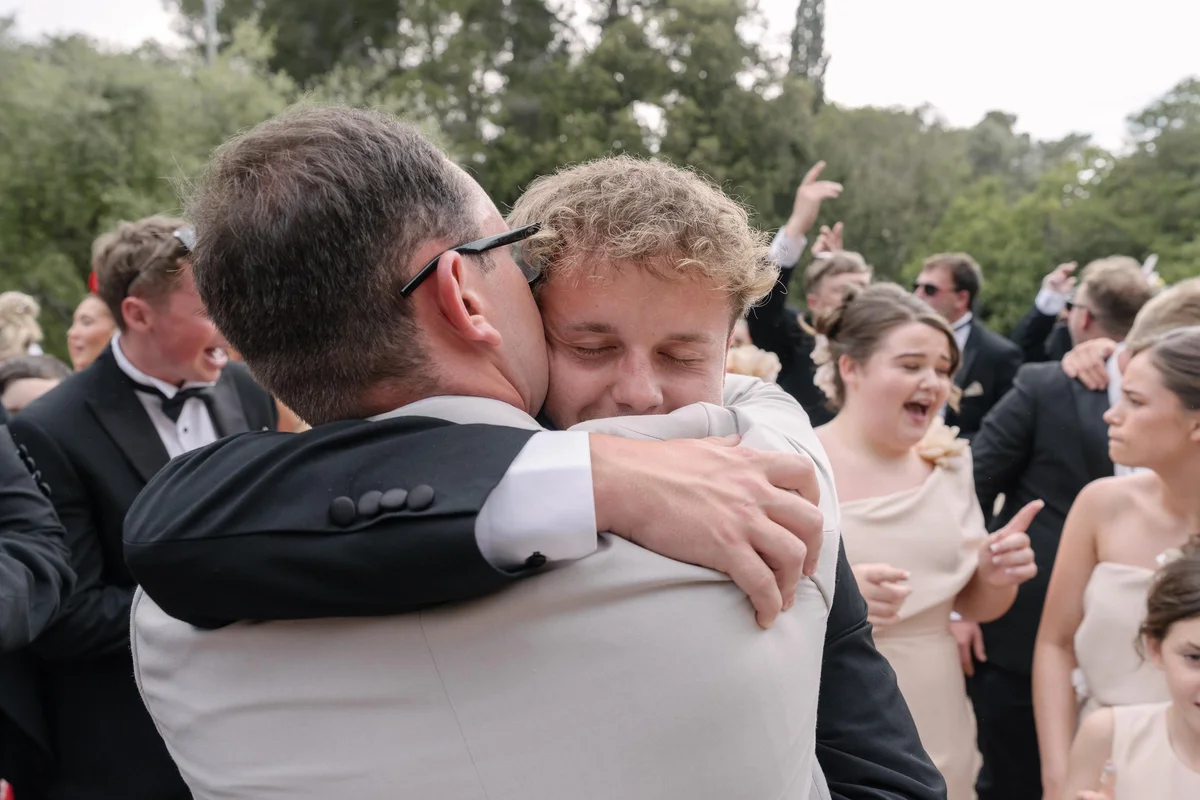 Wedding guests sharing an embrace at Ellie and Ernie’s reception