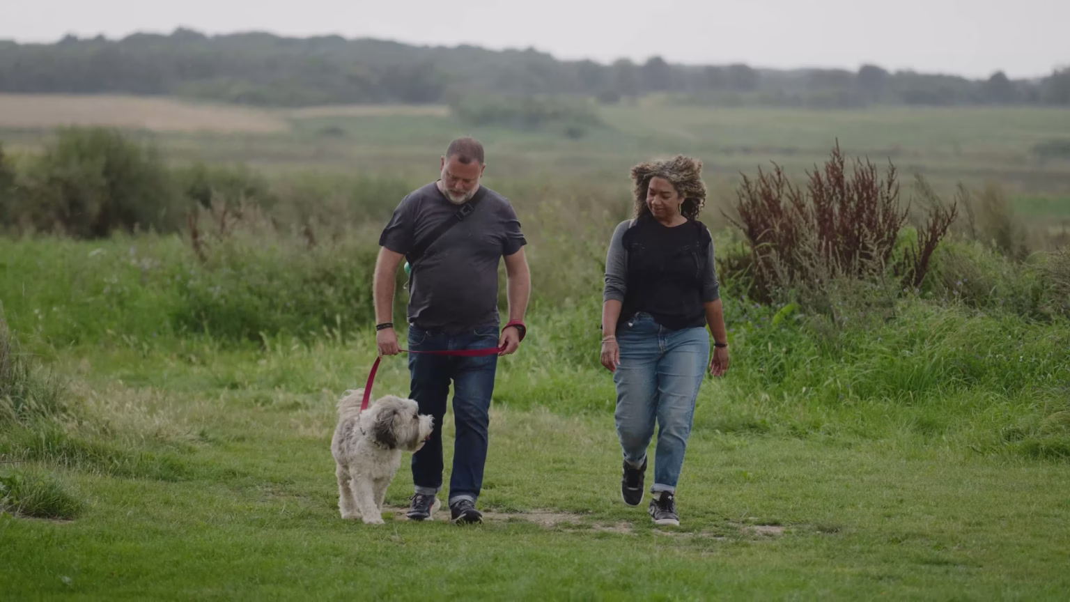 Couple walking their dog beside Old Hall Café in Suffolk
